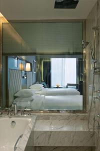 卢迪亚纳凯悦卢迪亚纳酒店的大型浴室设有两张床和浴缸。