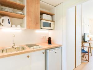 波连萨港太阳俱乐部公寓式酒店的厨房配有水槽和微波炉