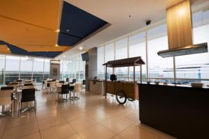 贝克西Hotel 88 Bekasi By WH的餐厅设有桌椅和大窗户。
