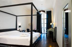 阿尔么丽亚阿尔梅里亚大教堂酒店的一间卧室配有一张天蓬床和一张书桌