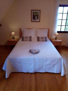 Saint-Martial-de-NabiratLe Coze的一间卧室配有一张带两盏灯的大型白色床。