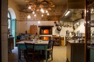 AragonaResort Fontes Episcopi的厨房配有桌椅和炉灶。