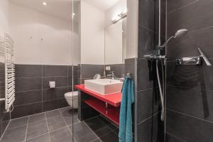 伯尔格伦德-雷特维施Seeresidenz的一间带红色盥洗盆和卫生间的浴室