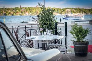 斯德哥尔摩Elite Hotel Marina Tower, Spa & Resort的水中带小船的白色桌椅