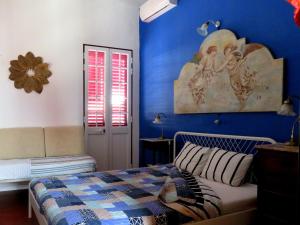 费雷拉杜阿连特茹Pátio das Andorinhas的一间卧室设有一张床和蓝色的墙壁