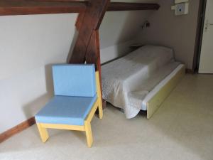 Mareuil-sur-CherLes Berges的小房间设有一张床和一张蓝色椅子