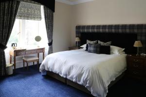 奈恩卡尔纳赫之家旅馆的一间卧室配有一张床、一张书桌和一个窗户。