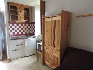Mareuil-sur-CherEscapade的一间带木制橱柜和冰箱的小厨房
