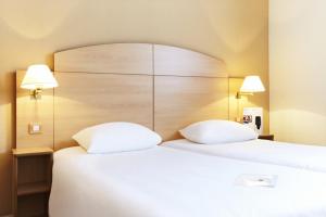 菲尔福尔德布鲁塞尔维尔福德钟楼酒店的配有两张枕头的床的酒店客房