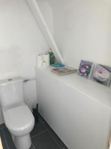 Regnéville-sur-MerChez Natacha et Adrien的白色的浴室设有卫生间,并拥有一些图片