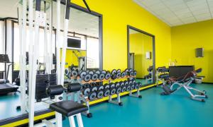 利勒斯特罗姆同恩运动场酒店的拥有黄色墙壁和大量设备的健身房
