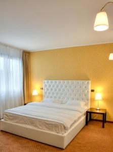 布朗阿尔盖洛旅馆的一张大白床,位于带两盏灯的房间