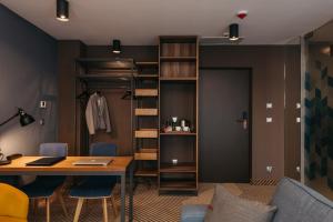 克拉科夫Avena Boutique Hotel by Artery Hotels的配有桌椅和衣柜的客房