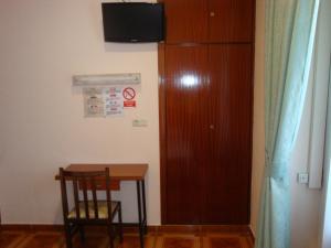 马德里萨莫拉旅馆的一间设有桌子、椅子和橱柜的房间