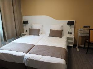 Ornolac-Ussat-les-BainsRésidence Thermale du Parc的一张大白色的床,位于酒店客房内