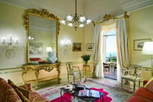 索伦托伊克斯西尔维多利亚大酒店的客厅配有镜子和桌子