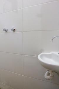 乌贝兰迪亚Vhostel的一间带水槽和白色瓷砖墙的浴室