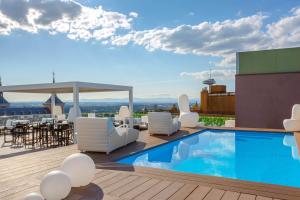 马德里埃克蒙克洛亚酒店的一座带桌椅的建筑屋顶游泳池
