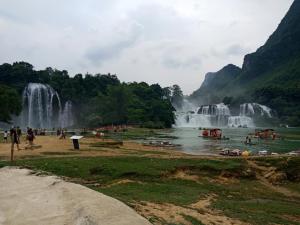 Dam ThuyNhà Nghỉ Kiều Thanh Nguyệt - Bản Giốc的一群人,在瀑布前的海滩上