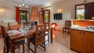 扎金索斯镇Pothos Villas的厨房以及带木桌和椅子的客厅。