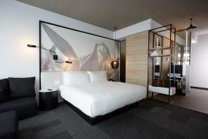 布罗瑟德Hôtel Escad Quartier DIX30的卧室配有白色的床和沙发