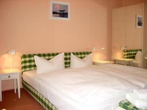 奥斯纳布吕克诺伊施塔特酒店的一间卧室配有一张白色大床和绿色床头板