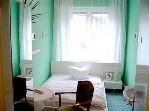 奥斯纳布吕克诺伊施塔特酒店的绿色的客房设有床和窗户。