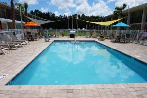 圣奥古斯丁Smart Stay Inn - Saint Augustine的一个带椅子和遮阳伞的大型蓝色游泳池