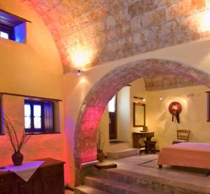 莫奈姆瓦夏阿达米斯酒店的卧室设有拱门,卧室内设有一张床