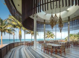 邦沙潘河內班赛通海滩度假酒店的海滩上的餐厅,配有桌椅