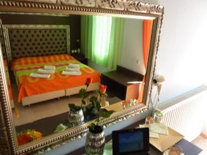 奥林匹亚基·阿克蒂白玫瑰海滩酒店的一张桌子上的镜子,一张床上的镜子