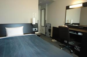 十和田十和田航线客栈酒店的一间卧室配有一张床、一张书桌和一面镜子