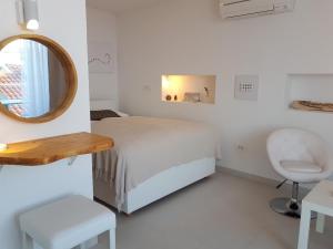 杜布罗夫尼克Alto Rooms and Apartments的一间卧室配有一张床、镜子和椅子