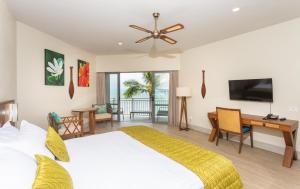 拉罗汤加Moana Sands Lagoon Resort - Adults Only的一间卧室配有一张床、一张书桌和一台电视