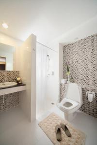 普吉镇桑空宫酒店的浴室配有卫生间、淋浴和盥洗盆。