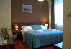Kochanów可哈诺酒店的酒店客房,配有带毛巾的床