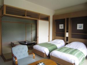 草津草津斯巴克斯酒店 的酒店客房,配有两张床和椅子
