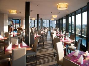布拉格伽利略酒店的餐厅设有桌椅和窗户。