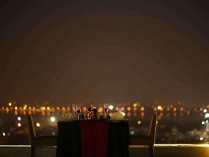 海得拉巴Mercure Hyderabad KCP Banjara Hills, An Accor Hotel的一张带酒杯的桌子,享有城市美景