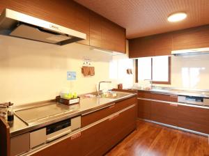 高山高山绿洲K之家旅舍的厨房配有木制橱柜、水槽和柜台。