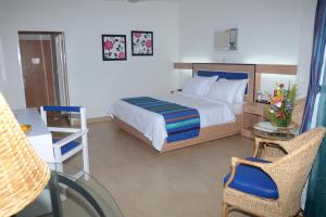 ShādipurPeerless Resort Port Blair的一间卧室配有一张床、一张桌子和一把椅子
