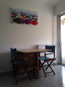 罗克布吕讷-卡普马丹Les Caroubiers的一张带两把椅子的木桌和墙上的一幅画