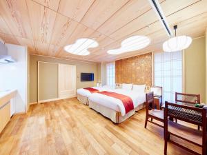 京都日升套房酒店的一间大卧室,配有一张大床和木地板