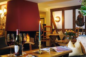 施马伦贝格佳德豪斯维泽酒店的一张带蜡烛和两瓶葡萄酒的桌子