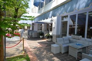格拉多埃里卡别墅酒店的一座配有白色家具的建筑外的庭院