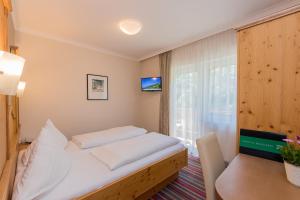 萨尔巴赫奥博尔达纳尔乡村酒店的一间卧室配有一张床、一张桌子和一个窗户。