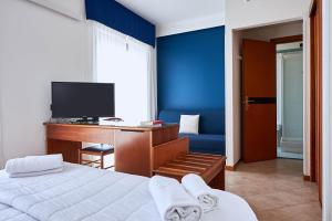 因佩里亚克罗齐迪马耳他酒店的一间卧室配有一张床和一张书桌及电视
