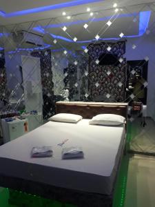 阿拉卡茹Motel Flex Love (Adults Only)的一间设有床铺的卧室,位于一间灯光的房间