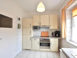 维斯马Spacious Holiday Home in Wismar Germany with Parasol的厨房配有白色橱柜和炉灶烤箱。