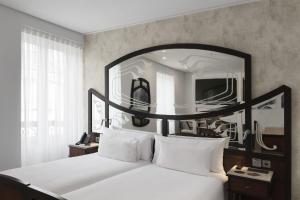马德里ICON Casona 1900的卧室配有大镜子,位于床上方